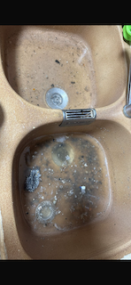 Técnico desatascando fregadero de cocina con espiral eléctrica en Terrassa